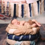 Baby liegend vor Steinmauer