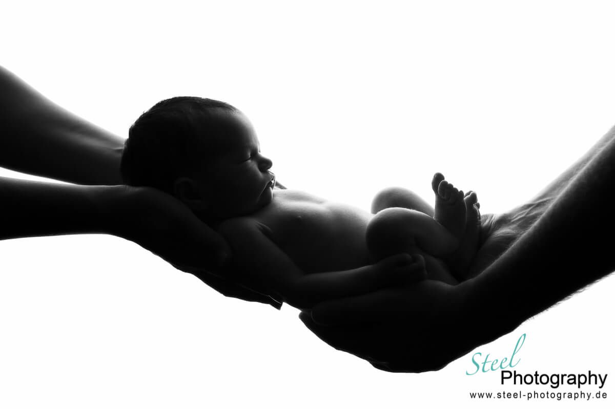 Baby in den Armen der Eltern von Steel Photography