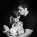 Liebevolles Familienbild Eltern küssen Baby