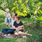 Familie im Garten zwischen Obstbäumen