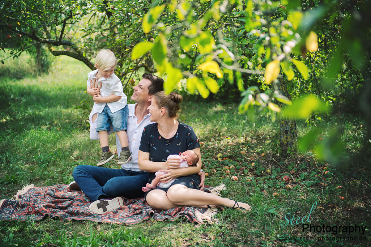 Familie im Garten zwischen Obstbäumen