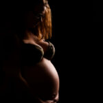 Babybauchfoto von der Seite mit wenig Licht