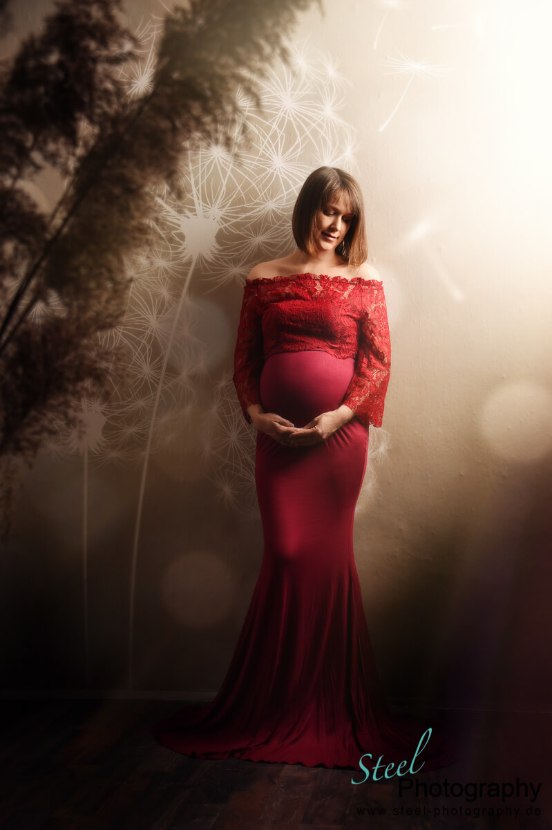 Werdende Mama stehend im roten Kleid