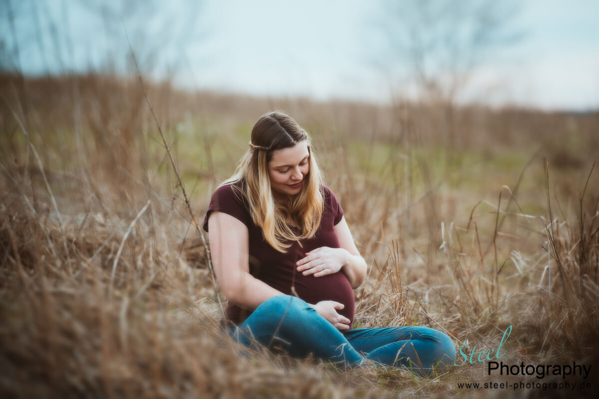 Schwangere sitzt im Gras